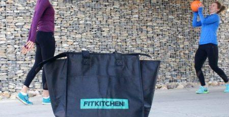 2 youg girls playing with a ball in the background of Fitkitchen delivery bag