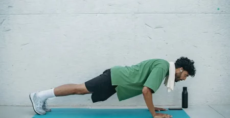 A man doing push ups next to a wall, representing muscles and stamina gain from healthy food.